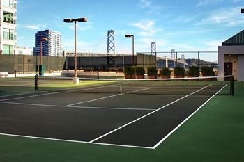 a tennis court with a city in the background